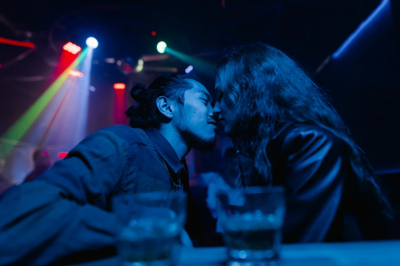 a couple of people that are kissing each other, inspired by Nan Goldin, pexels, happening, nightclub, blue, people enjoying the show, lee madgwick & liam wong