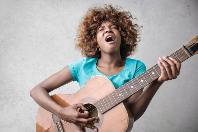 a close up of a person holding a guitar, by Ella Guru, shouting, black young woman, on grey background, capricious