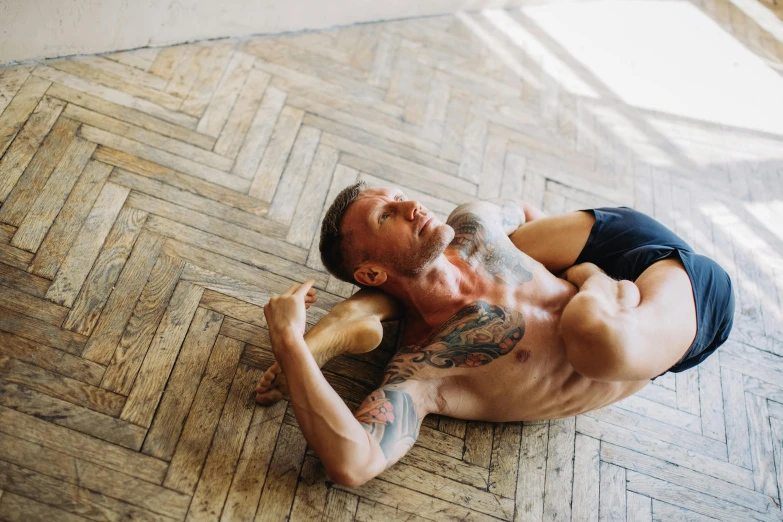 a man laying on the floor with a tattoo on his chest, pexels contest winner, renaissance, yoga, muscular men entwined together, gif, anna nikonova