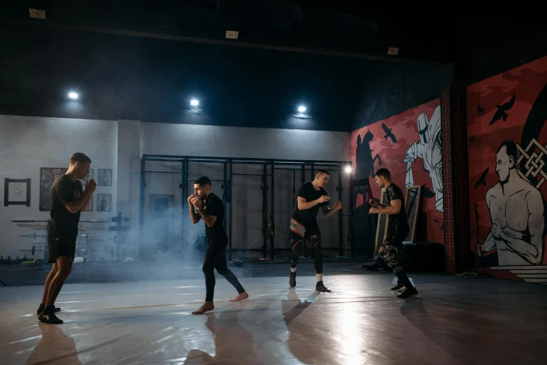 a group of people standing on top of a dance floor, pexels contest winner, graffiti, heroic muay thai stance pose, 3 actors on stage, in a black empty studio hollow, practice