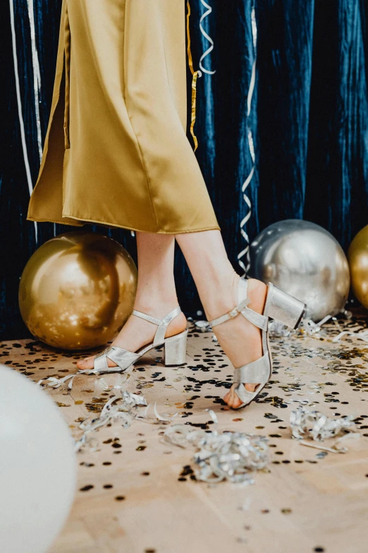 a woman standing in front of a bunch of balloons, wearing open toe heels, silver，ivory, parties, product shot