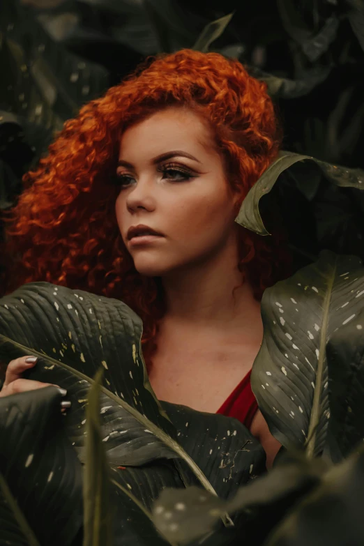 a woman with red hair is surrounded by leaves, inspired by Elsa Bleda, trending on pexels, renaissance, big hair, tropical, digital photo, curls on top