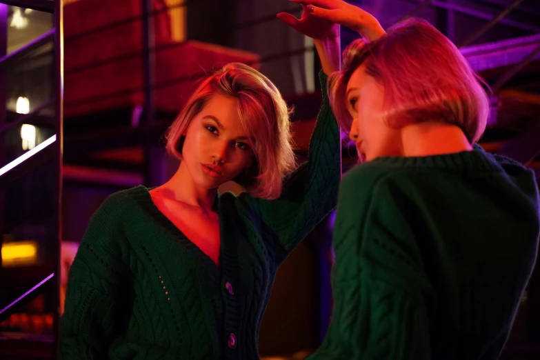 a woman taking a picture of herself in a mirror, inspired by Elsa Bleda, trending on pexels, digital art, neon operator margot robbie, wearing a green sweater, nightlife, with a bob cut