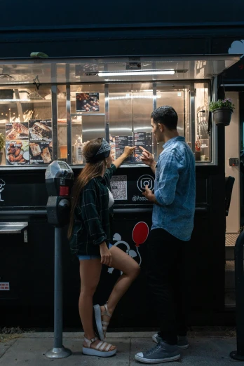 a couple of people standing next to a parking meter, by Niko Henrichon, pexels contest winner, people inside eating meals, nighthawks, 15081959 21121991 01012000 4k, panoramic shot