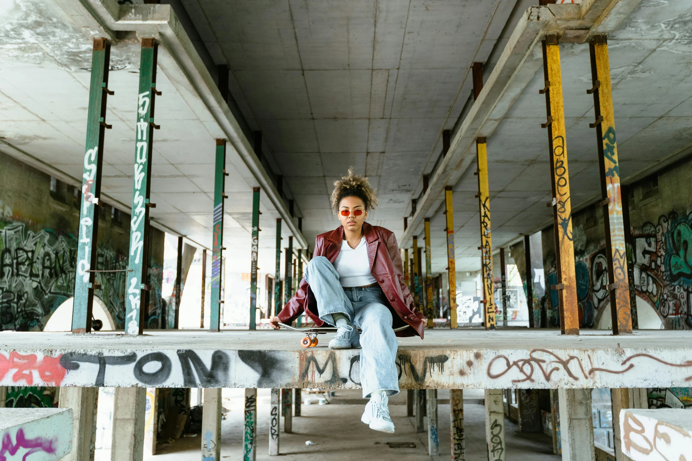 a woman sitting on top of a wooden bench, trending on pexels, graffiti, 80s photo, sitting under bridge, androgynous person, in a warehouse