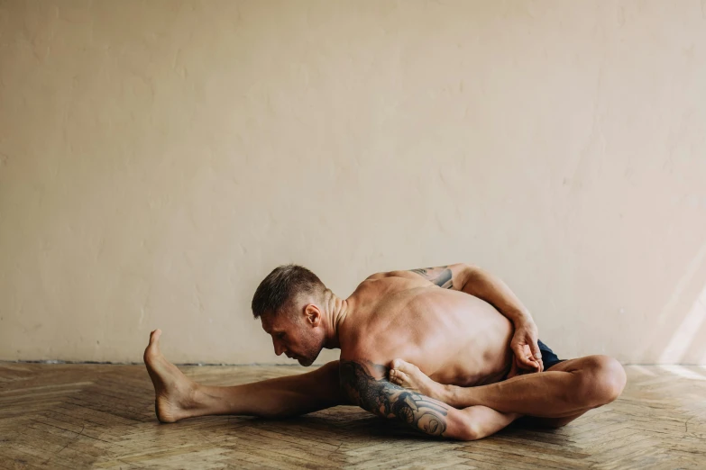 a man is doing a yoga pose on the floor, by Matija Jama, pexels contest winner, renaissance, fleshy musculature, multi-part, lane brown, half-body