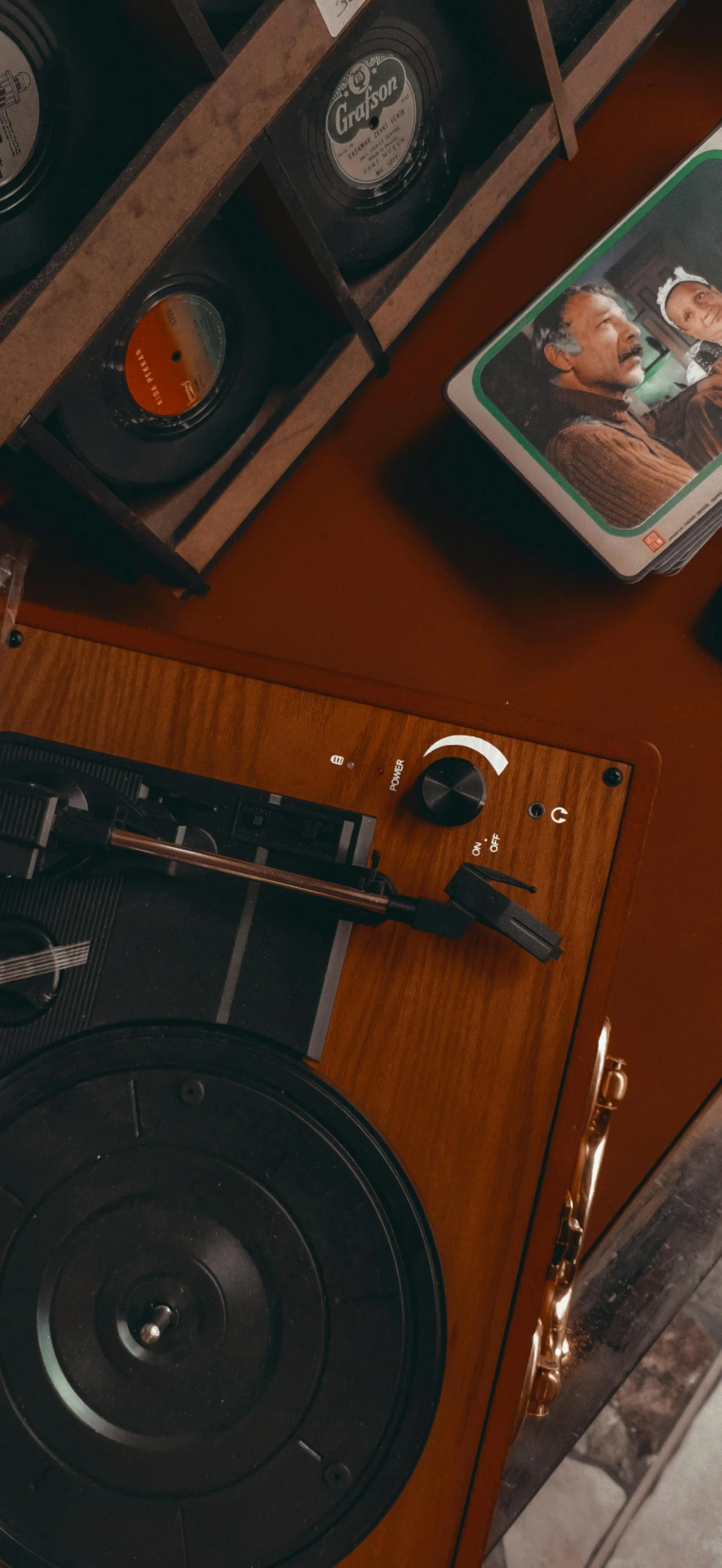 a record player sitting on top of a wooden table, an album cover, inspired by Elsa Bleda, trending on pexels, analytical art, movie scene close up, cinematic. by leng jun, atelier olschinsky, retro machinery