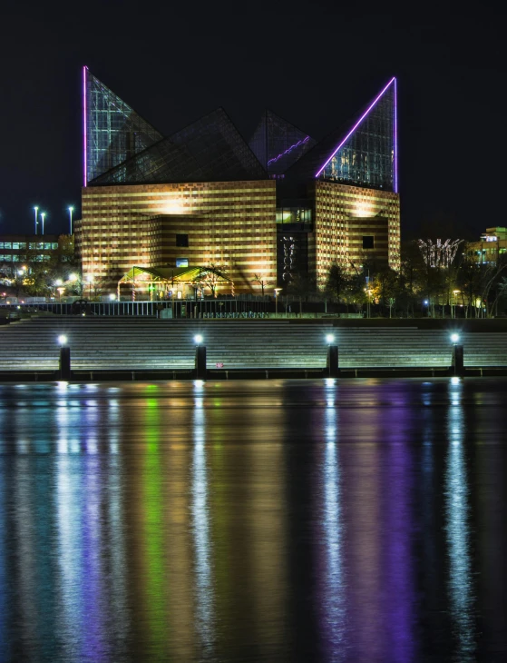 a large building sitting next to a body of water, a hologram, by Dave Melvin, pexels contest winner, corporate memphis, viewed from the harbor, ::