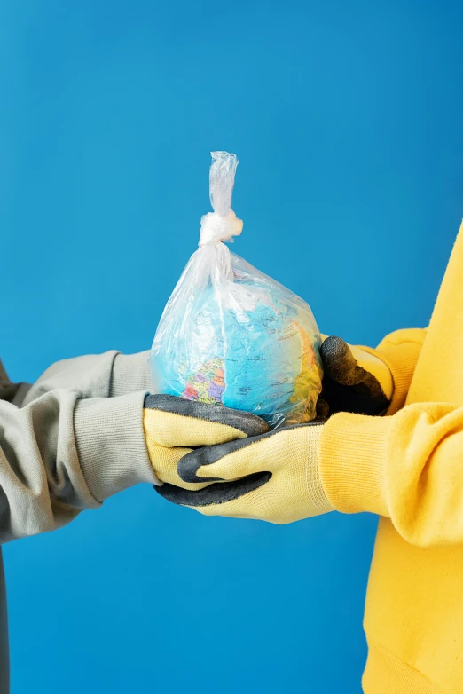 a man and a woman holding a globe in their hands, a colorized photo, inspired by Jeff Koons, shutterstock contest winner, plasticien, wearing a plastic garbage bag, yellow and blue and cyan, getting groceries, coronavirus as a stuffed toy