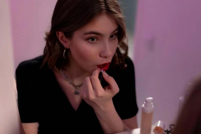 a woman sitting at a table eating a strawberry, sephora, imogen poots, putting on lipgloss, dua lipa