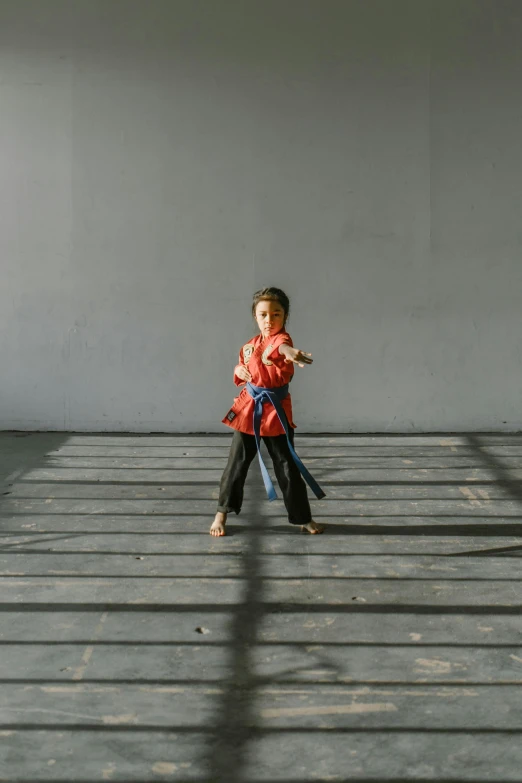 a little boy that is standing in a room, inspired by Ma Quan, pexels contest winner, in a fighting stance, on the concrete ground, gif, orange gi