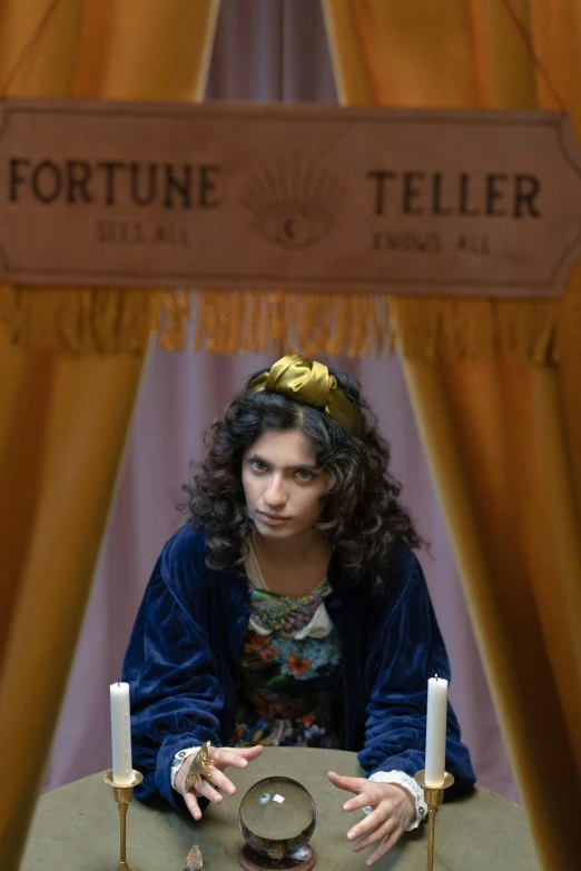 a woman sitting at a table holding a crystal ball, by Nathalie Rattner, mahira khan as a mage, fortune teller, curly haired, [ theatrical ]