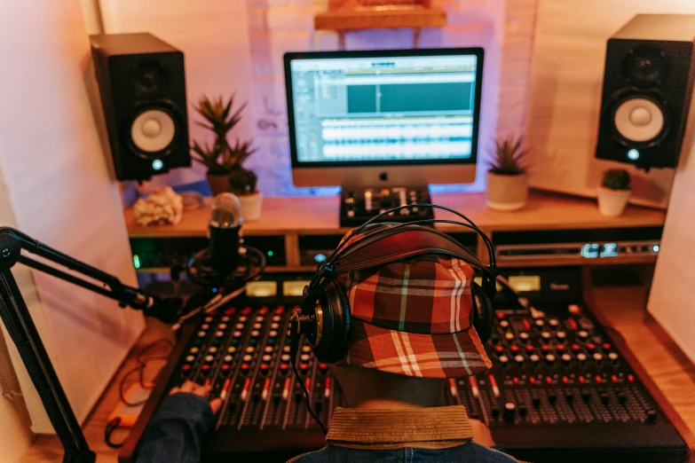 a person sitting at a desk in front of a computer, an album cover, trending on pexels, studio microphone, headphones on head, general studio lighting, thumbnail