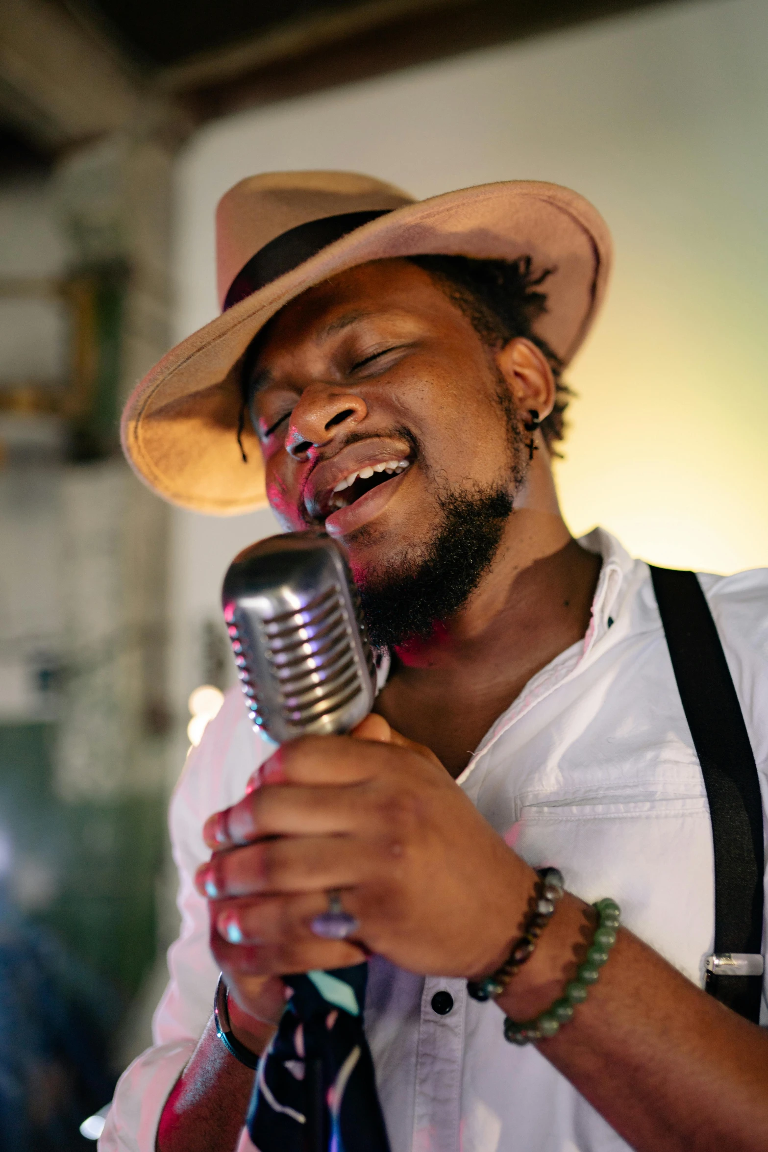 a man in a hat singing into a microphone, inspired by Candido Bido, trending on pexels, renaissance, emmanuel shiru, looking hot, square, brown