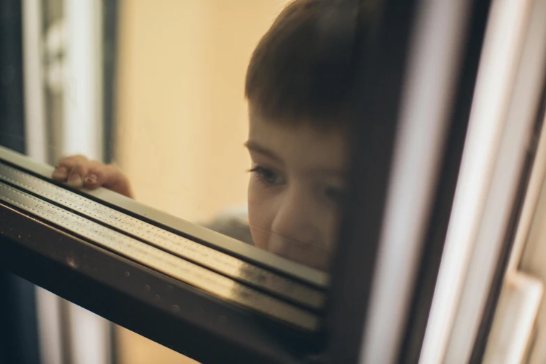 a close up of a child looking out a window, an album cover, pexels contest winner, infinity mirror, school class, soft light.4k, lachlan bailey