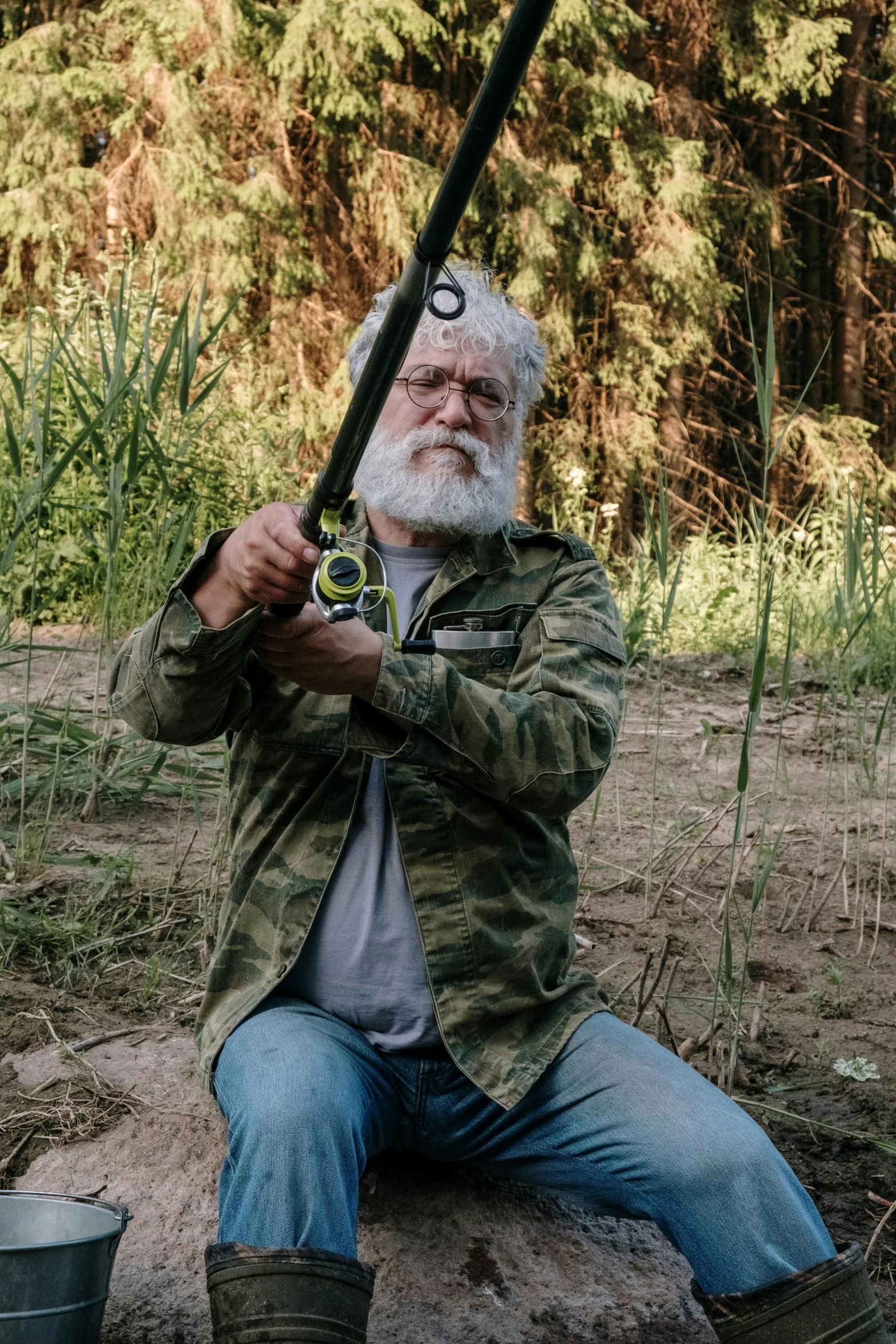 a man sitting on a rock holding a fishing rod, inspired by George Lucas, featured on reddit, renaissance, overalls and a white beard, holding a laser gun, high quality photo, wearing camo