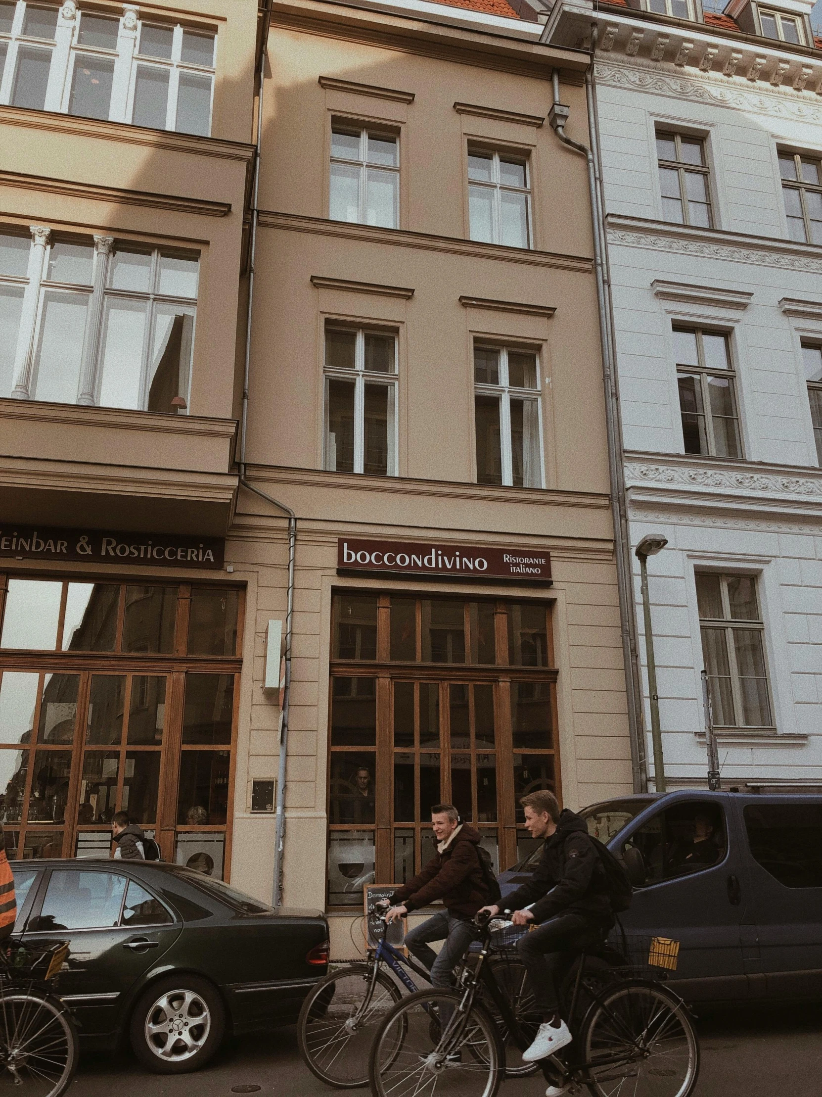 a group of people riding bikes in front of a building, bogna gawrońska, trending on vsco, coffee shop, very comfy]