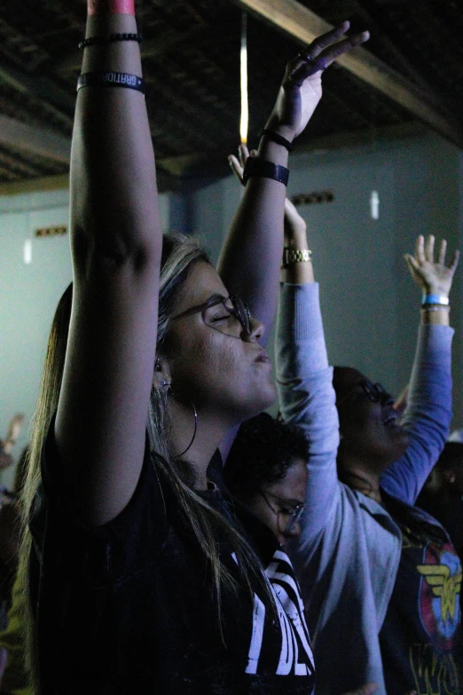 a group of people raising their hands in the air, listening to godly music, in sao paulo, alexis franklin, eyes closed