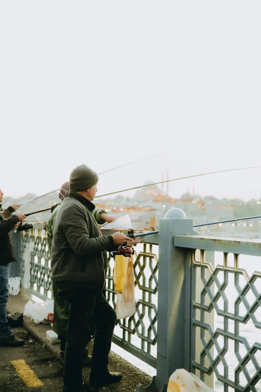 a group of people standing on top of a bridge, fishing, istanbul, taken on a 2000s camera, banner