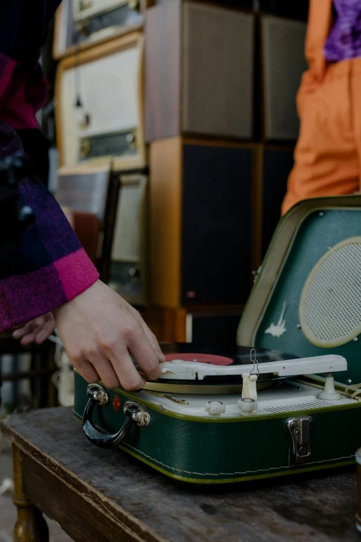 a green suitcase sitting on top of a wooden table, an album cover, by Niko Henrichon, trending on unsplash, happening, musicians playing instruments, 7 0 s hi fi system, inspect in inventory image, 1 9 5 0 s