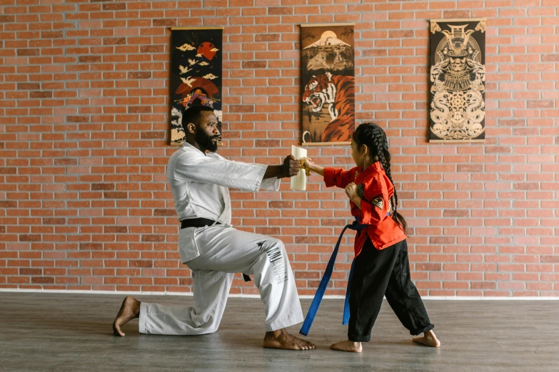 a man teaching a little girl how to do karate, a cartoon, inspired by Ma Quan, pexels contest winner, hurufiyya, samurai with afro, color photograph, brown, malaysian