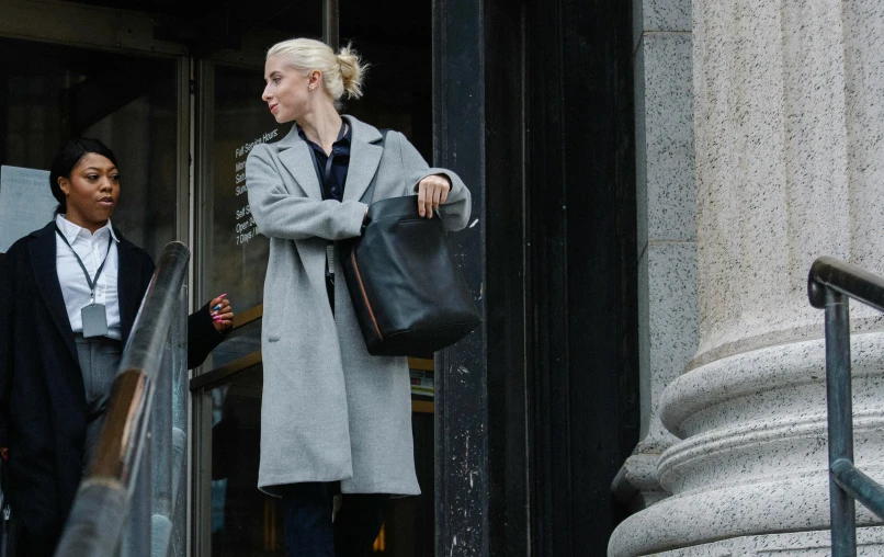 two women standing next to each other in front of a building, inspired by Louisa Matthíasdóttir, minimalism, leather duffle coat, anomalisa, in gunmetal grey, worksafe. cinematic