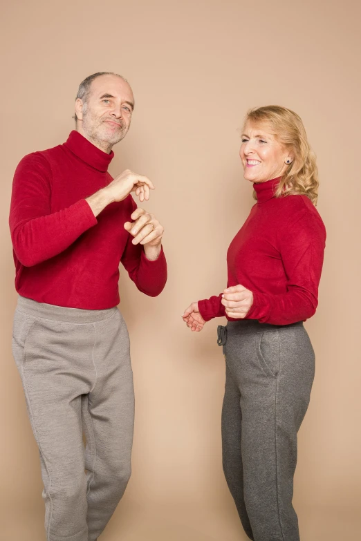 a man and a woman standing next to each other, by Sven Erixson, trending on pexels, antipodeans, red sweater and gray pants, silly, wearing turtleneck, pointè pose