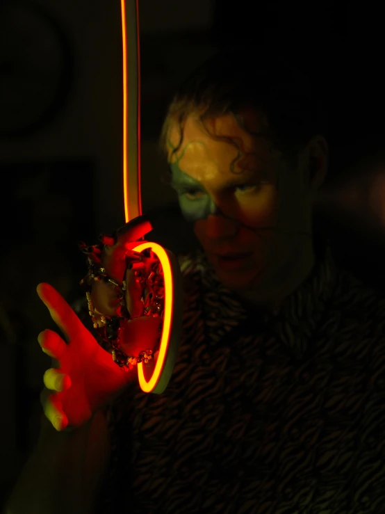 a man holding an umbrella in the dark, by Thomas Furlong, kinetic art, holding a rainbow tiger gem, translucent neon, ambient amber light, holding flask in hand