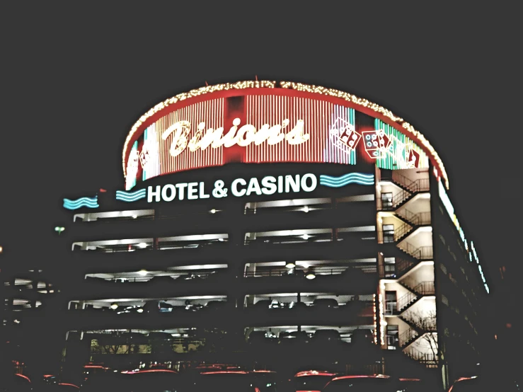a hotel and casino sign lit up at night, a colorized photo, unsplash contest winner, 🎨🖌️, billions of details, brandon, bling