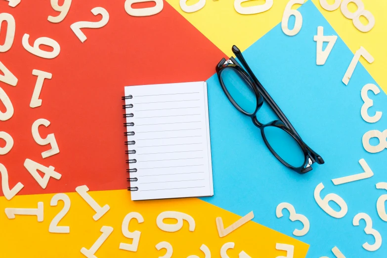 a notepad sitting on top of a pile of numbers, by Julia Pishtar, art & language, square rimmed glasses, multicoloured, thumbnail, teacher