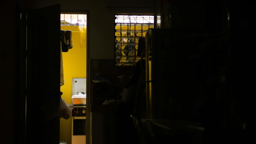 an open door leading into a dark room, by Elsa Bleda, pexels contest winner, arte povera, inside a cluttered kitchen, yellow hue, stood in a cell, a still of kowloon