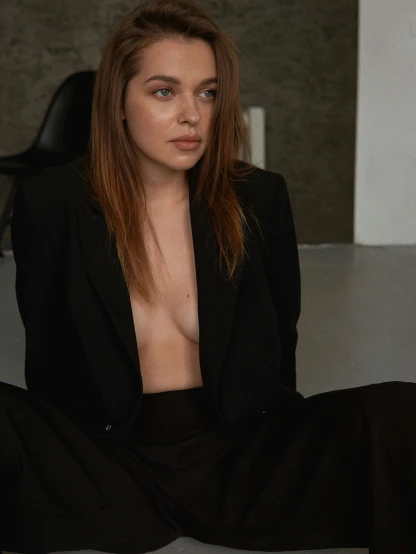 a woman in a black suit sitting on the floor, by Attila Meszlenyi, trending on unsplash, renaissance, breasts covered and sfw, portrait sophie mudd, subject detail: wearing a suit, sydney sweeney