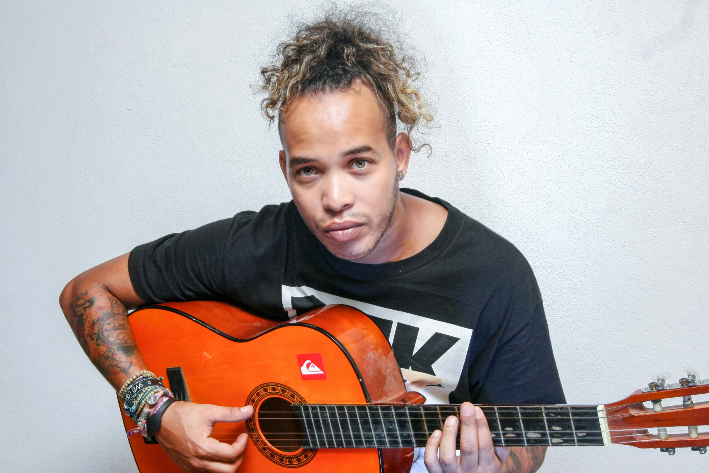 a close up of a person holding a guitar, an album cover, mixed race, smug look, looking towards camera, avatar image