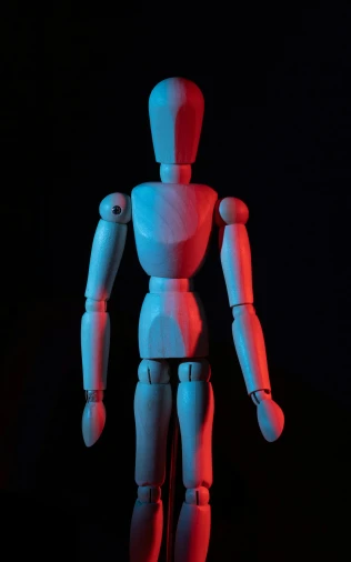 a wooden mannequin standing in front of a black background, a raytraced image, by David Donaldson, pexels, light red and deep blue mood, articulated joints, toy photo, hurt