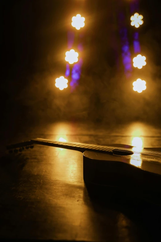 a guitar sitting on top of a wooden table, by Matt Cavotta, pexels contest winner, light and space, smokey lights, stage lights, trending on mentalray, lights with bloom