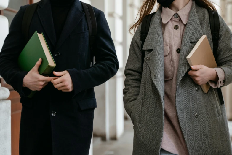 a man and a woman are walking down the street, trending on pexels, renaissance, holding books, academic clothing, close up half body shot, high school