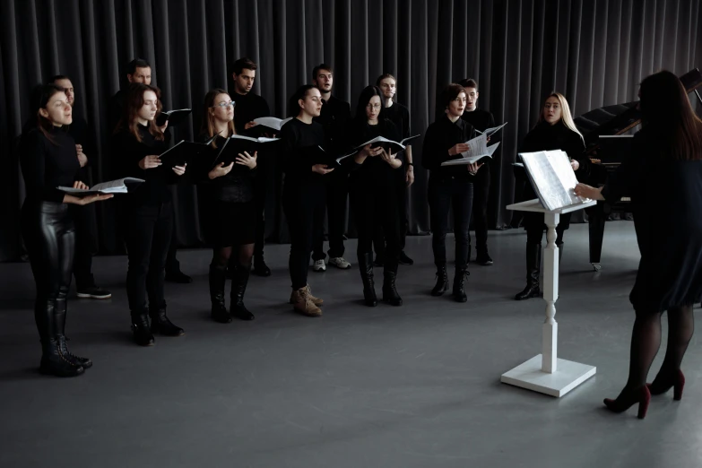 a group of people standing in front of a microphone, unsplash, antipodeans, choir, on a gray background, sheet music, herzog de meuron