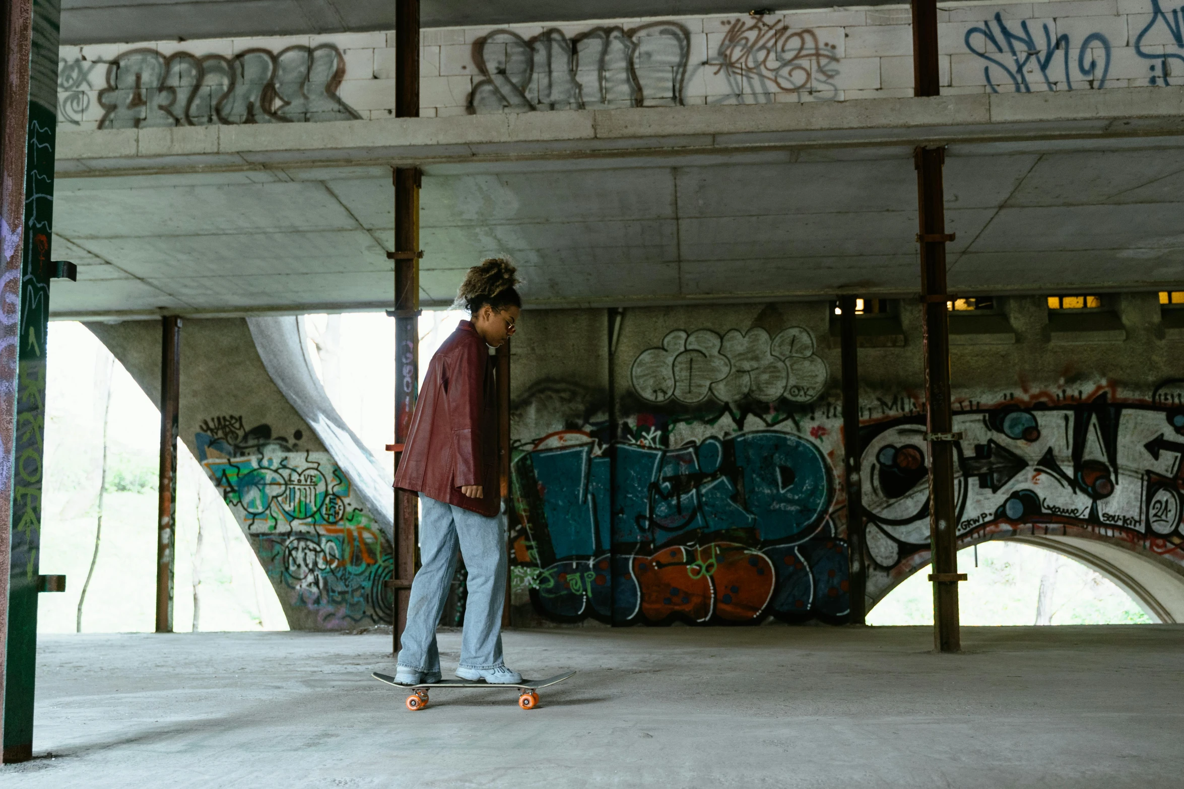 a man riding a skateboard under a bridge, unsplash, graffiti, standing in abandoned building, frank dillane as puck, female marty mcfly, cinematic outfit photo