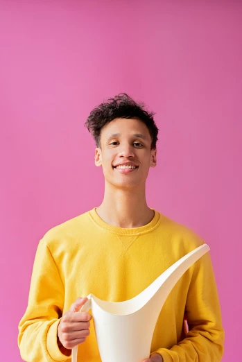 a man in a yellow shirt holding a white vase, trending on pexels, academic art, pink shirt, male teenager, grinning lasciviously, non binary model