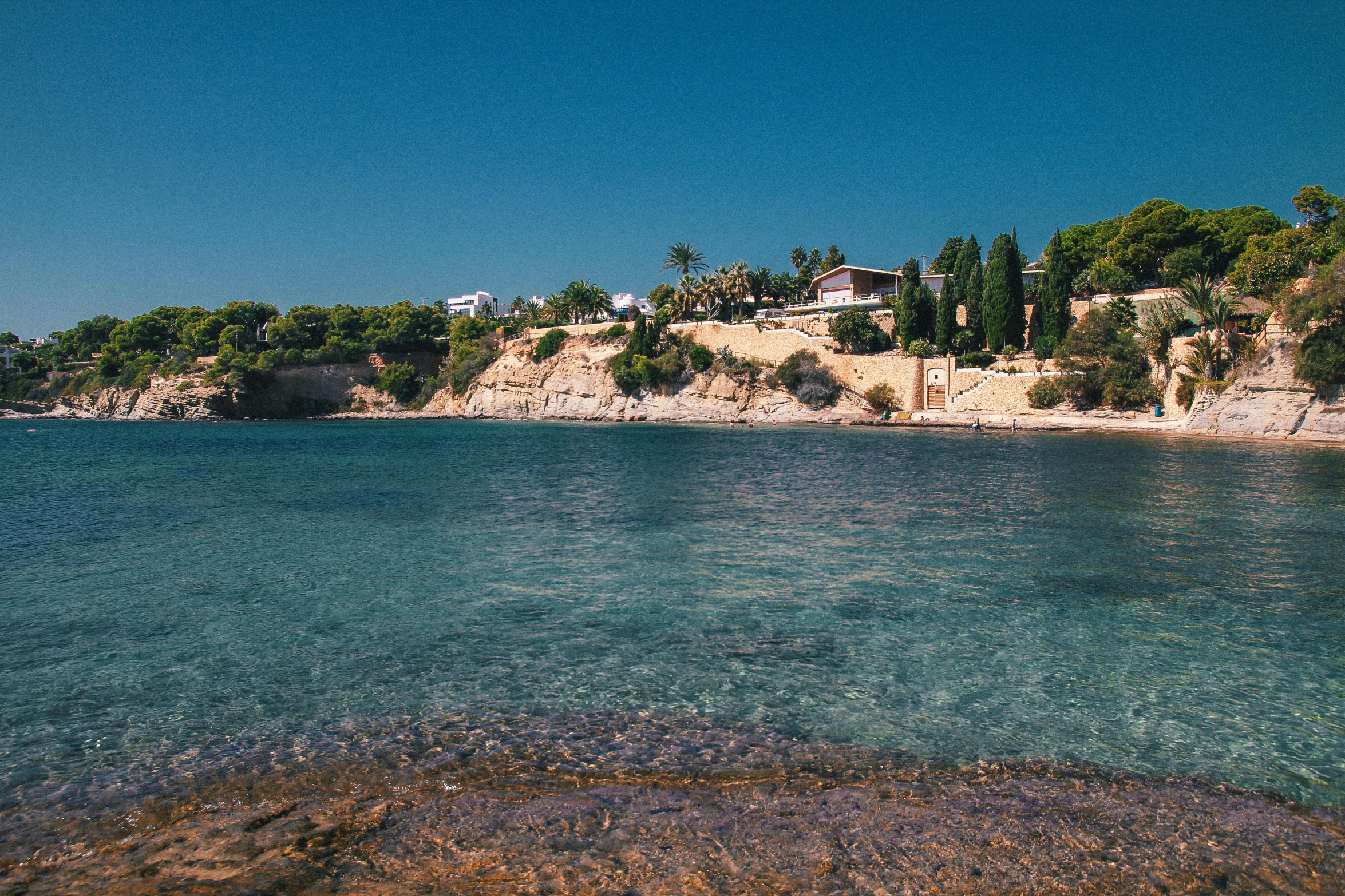 a large body of water next to a beach, unsplash, les nabis, costa blanca, 2 0 0 0's photo