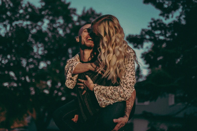 a man carrying a woman in his arms, pexels contest winner, 🤬 🤮 💕 🎀, flirting smiling, magic hour, blonde