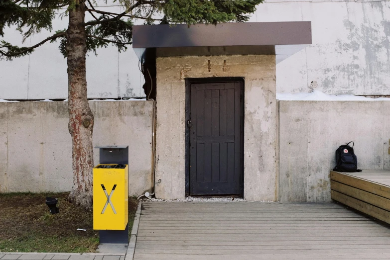 a person sitting on a bench in front of a building, an album cover, by Attila Meszlenyi, postminimalism, yellow charcoal, opposite the lift-shaft, hyperrealistic image of x, letterbox