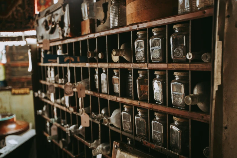 a number of jars on a shelf in a room, a screenshot, pexels contest winner, assemblage, scientific instruments, crafts and souvenirs, vials, vintage film stock