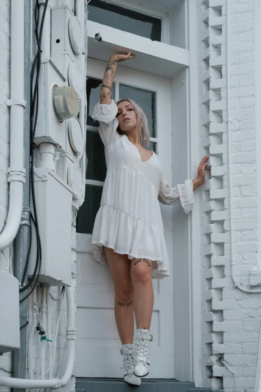 a woman in a white dress standing on a porch, inspired by Elsa Bleda, pexels contest winner, renaissance, short minidress, white background, performing a music video, sydney sweeney