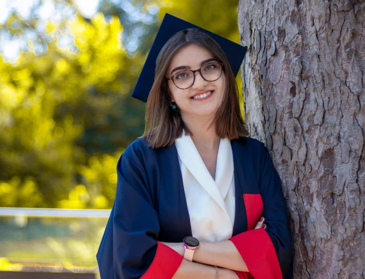 a woman in a graduation gown leaning against a tree, by Julia Pishtar, pexels contest winner, academic art, handsome girl, greek ameera al taweel, 15081959 21121991 01012000 4k, navy