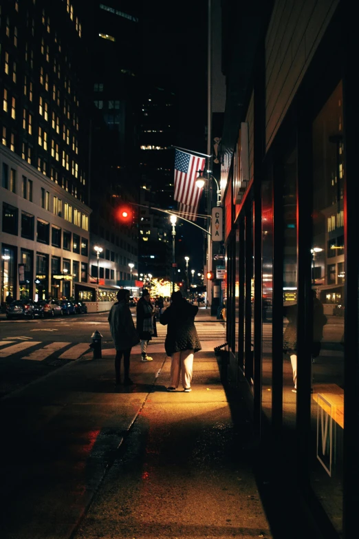 a group of people walking down a street at night, pexels contest winner, visual art, new york buildings, romantic scene, street corner, americana