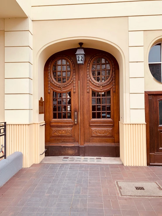 a red fire hydrant sitting on the side of a building, a photo, art nouveau, symmetrical doorway, carved in wood, villany, round doors