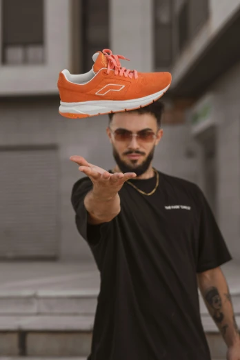 a man balancing a shoe on his head, a picture, pexels contest winner, wearing an orange t-shirt, ✨🕌🌙, floro details, avatar image