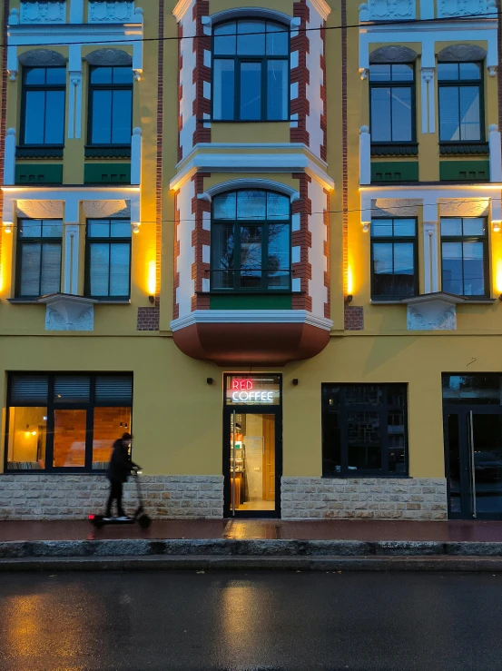 a person walking down the street in front of a building, neo kyiv, yellow lighting from right, award winning shopfront design, profile image
