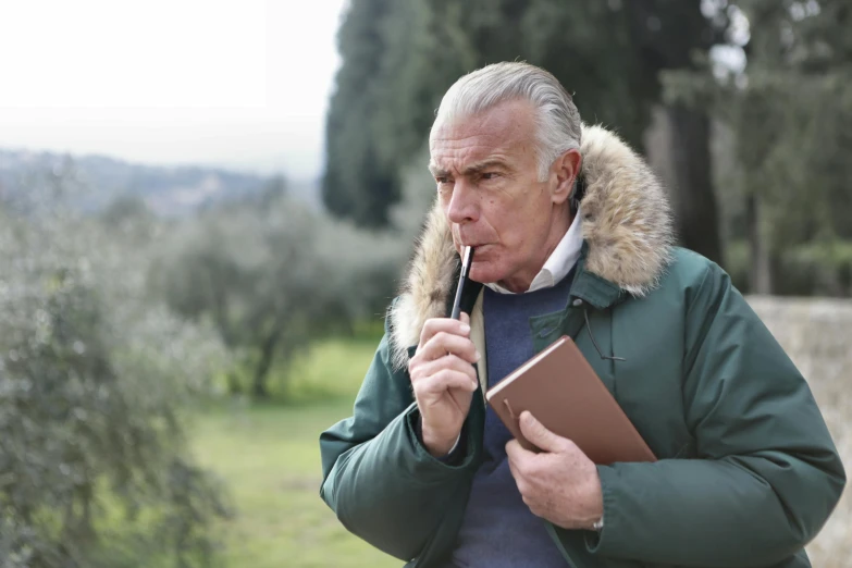 a man smoking a cigarette and holding a book, by Giuseppe Avanzi, pexels contest winner, hiking cane, rome in background, cedar, sean connery